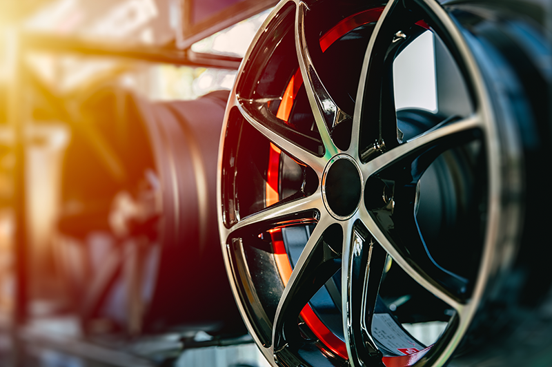 Close-up of a shiny black alloy car wheel rim with a multi-spoke design